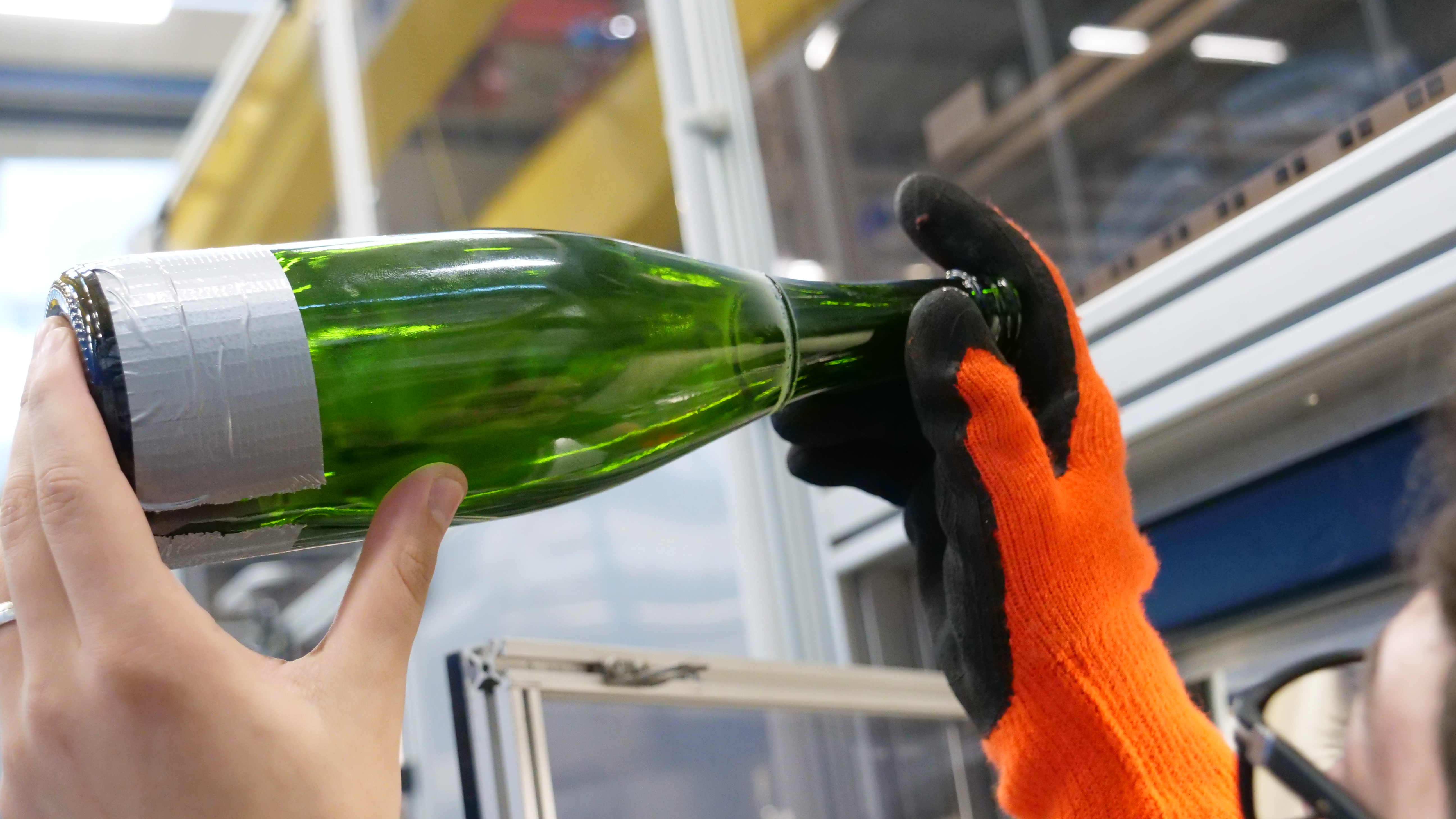Mit dem Laser haben die Wissenschaftler:innen der Gruppe Glas die Hälse der Weinflaschen abgetrennt. 