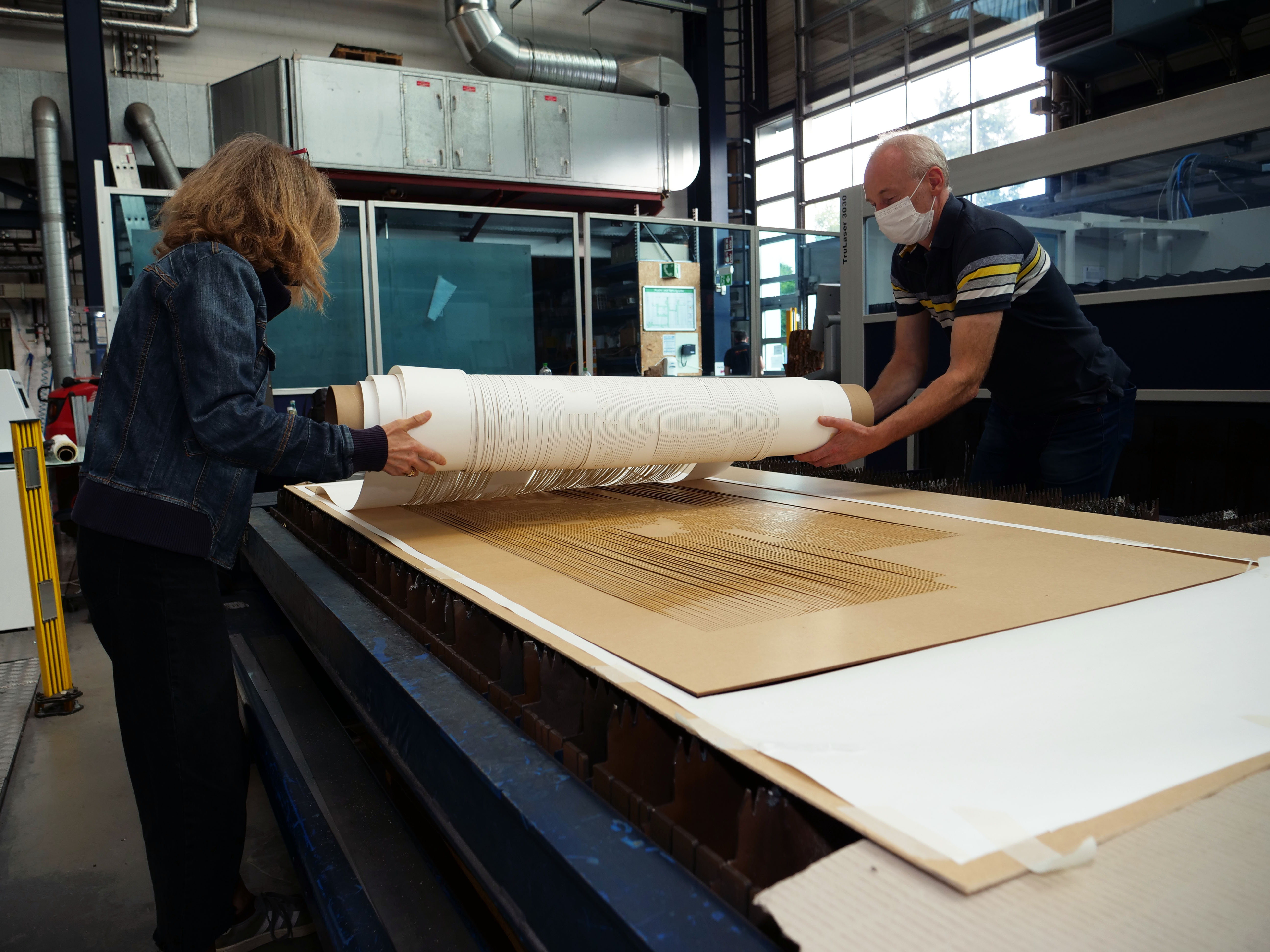 Matthias Schrader, Techniker am LZH, holt zusammen mit der Künstlerin Susanne Specht die fertig geschnittenen Kunstwerke aus der Anlage. (Foto: LZH)