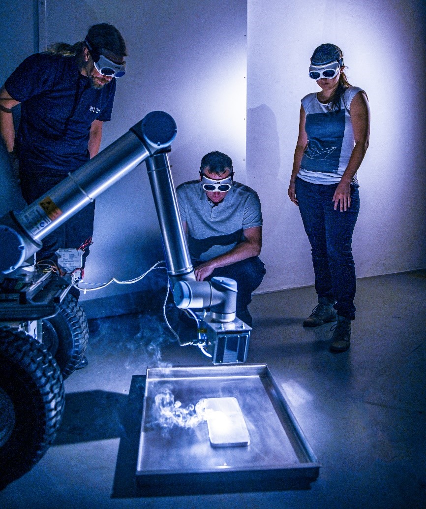 Der MOONRISE-Laser integriert am Robotorarm des Mondrover MIRA3D des IRAS: Der Laser schmilzt erfolgreich ganze Bahnen aus Regolith auf. (Foto: LZH)