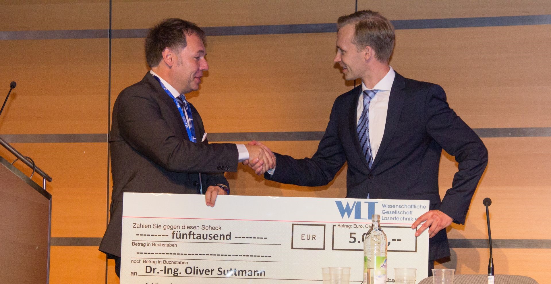 Prof. Dr.-Ing Michael Schmidt (links), Präsident der Wissenschaftlichen Gesellschaft Lasertechnik e.V. (WLT), überreicht den WLT-Preis an Dr.-Ing. Oliver Suttmann, Abteilungsleiter am LZH. (Foto: LPT, Felix Tenner)
