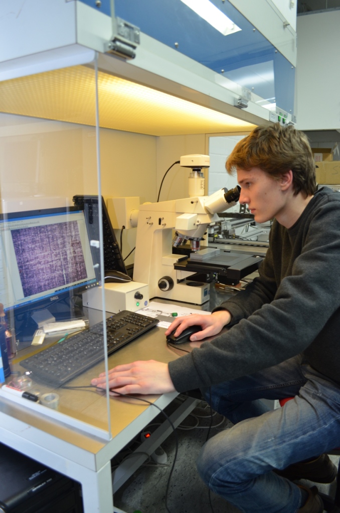 Bild 1: FWJ’ler Hauke Plate untersucht Optiken am Mikroskop. (Foto: LZH)