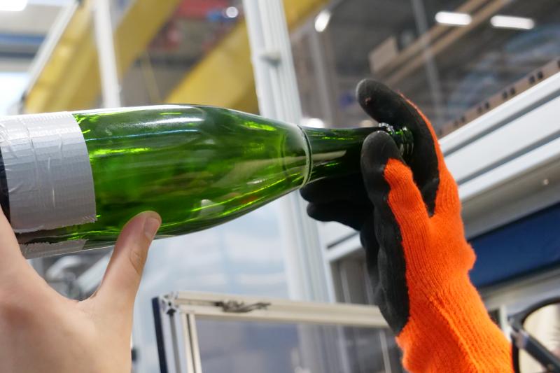 Mit dem Laser haben die Wissenschaftler:innen der Gruppe Glas die Hälse der Weinflaschen abgetrennt. 