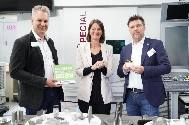 Foto mit Ministerin Staudte, Tammo Ripken und Dietmar Kracht, die an einem Tisch mit 3D-gedruckten Bauteilen stehen.
