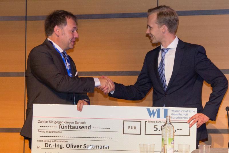 Prof. Dr.-Ing Michael Schmidt (left), President of the Wissenschaftliche Gesellschaft Lasertechnik e.V. (WLT), hands over the WLT Prize to Dr.-Ing. Oliver Suttmann, Head of Department at the LZH. (Photo: LPT, Felix Tenner)