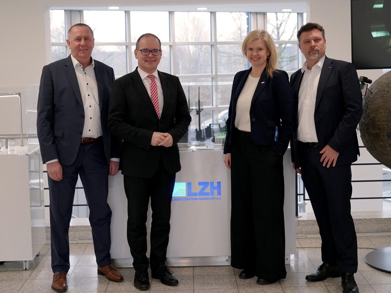 Minister Tonne steht mit den drei Geschäftsführenden Vorständen im Foyer des LZH.