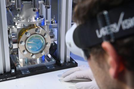 Wissenschaftler blickt mit Schutzbrille auf Laserprozess.